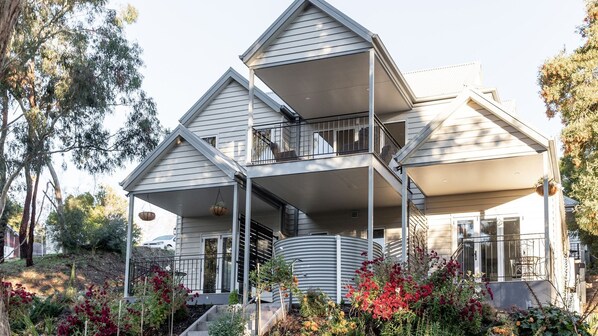 Une maison à plusieurs niveaux dotée d’un balcon et d’une véranda.