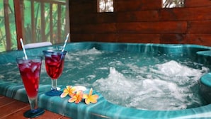 Un bain à remous avec deux boissons et des fleurs tropicales.