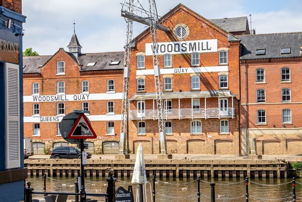 A historic building named Woodmill Quay with a prominent sign, a canal in front, and a pedestrian bridge overhead. - 30 Woodsmill Quay - sleeps 3 guests in 1 bedroom (York)