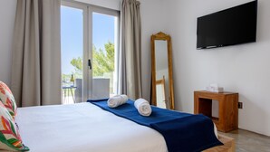 A hotel room with a bed, a TV, a large mirror, and a view of the outdoors. - Modern Luxury Villa,  - 10 mins to Cala Bassa - 15 mins to Jondal/Es Torrent (San Agustín)