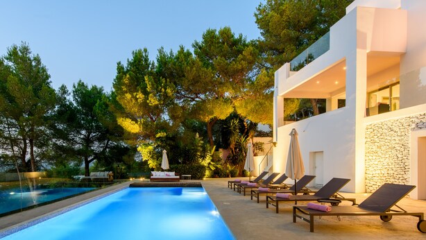 A modern pool area with a clear pool, lounge chairs, and a stone wall. - Modern Luxury Villa,  - 10 mins to Cala Bassa - 15 mins to Jondal/Es Torrent (San Agustín)