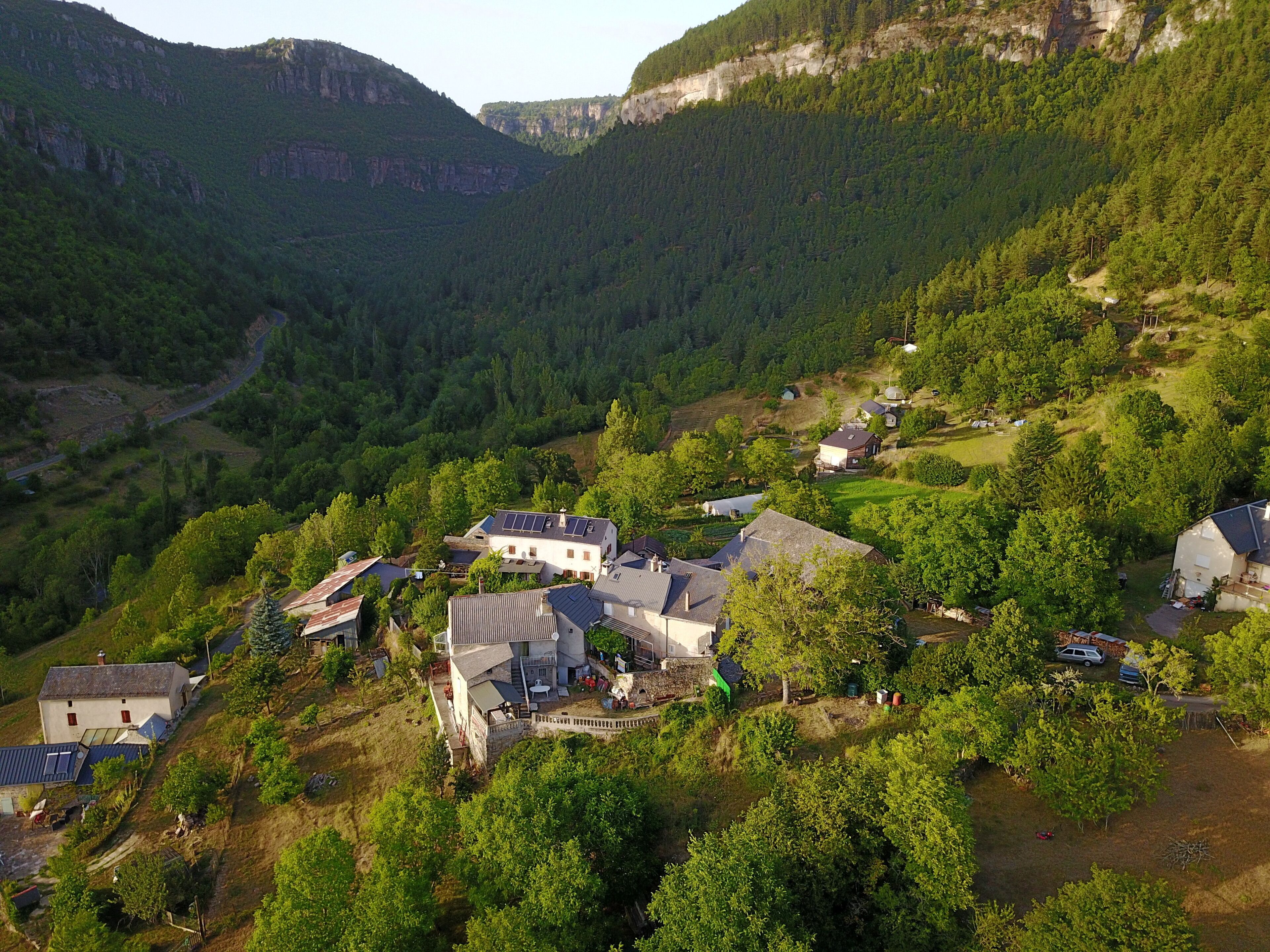 Un pueblo rural con casas rodeado de vegetación exuberante y montañas al fondo.