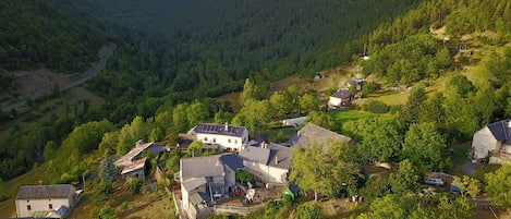 Un pueblo rural con casas rodeado de vegetación exuberante y montañas al fondo.