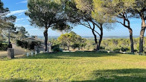 A grassy outdoor area with trees and a building in the background. - Modern villa - 5 bedrooms, in Uchaux village - private pool & amazing views (Uchaux)