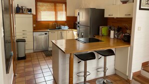 A compact kitchen with a central island, a dishwasher, a refrigerator, and a sink. - Modern villa - 5 bedrooms, in Uchaux village - private pool & amazing views (Uchaux)