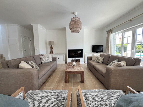 A modern living room with two sofas, a coffee table, and a TV.