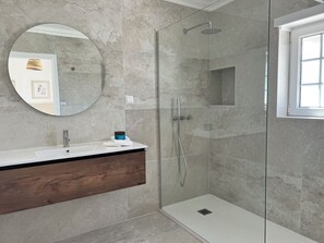 Een bad/douchecombinatie, een haardroger, een bidet, handdoeken