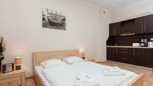 Une chambre d’hôtel équipée d’un lit, d’une table de chevet, d’une machine à café et d’un coin cuisine.