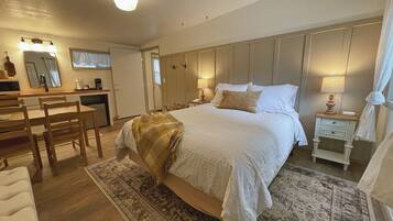 Une chambre à coucher avec un grand lit, des tables de chevet, un bureau et un miroir.