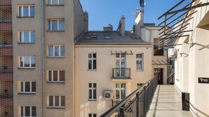 Un edificio de varios pisos con balcones, una escalera y cielo despejado.