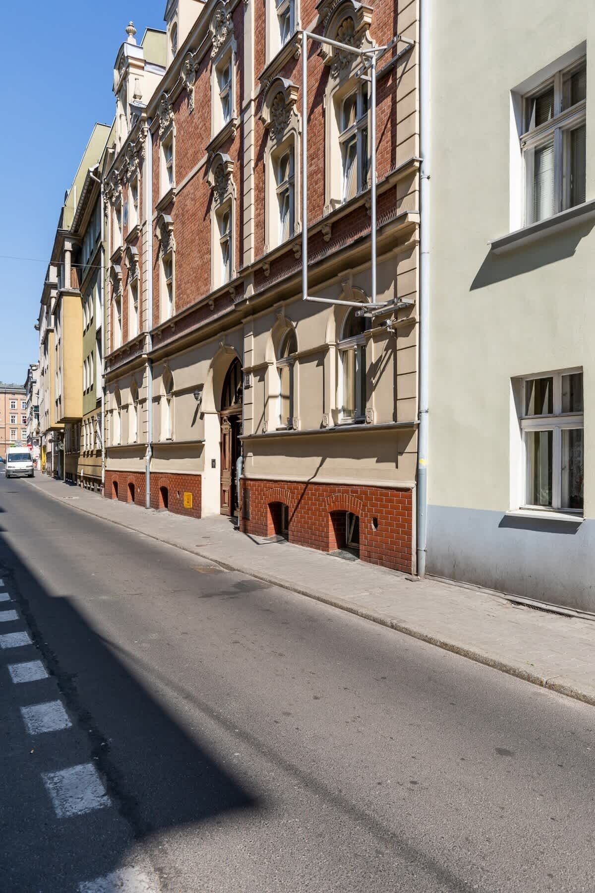Een straatbeeld met een rij meerverdiepinggebouwen, met klassieke architectuurelementen en een keurig geplaveid wegdek.