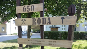 Un cartel de madera con información histórica y flechas indicativas.