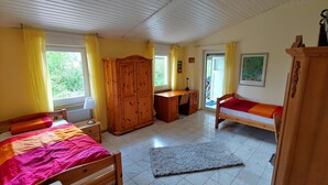 A bedroom with a bed, a desk, a wardrobe, and a small balcony. - Beautiful detached holiday home with a sunny location and panoramic views (Lissendorf)