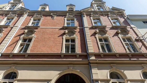 A multi-story building with classical architectural style, featuring symmetrical windows and decorative moldings. - Bright Apartment in the Center | 500 m from the Old Town Square (Poznan)