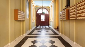 A hotel hallway with a checkered floor, a star pattern, and a chandelier. - Bright Apartment in the Center | 500 m from the Old Town Square (Poznan)