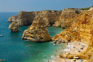 A coastal landscape with cliffs and a beach. - Apartment Rui (Carvoeiro)