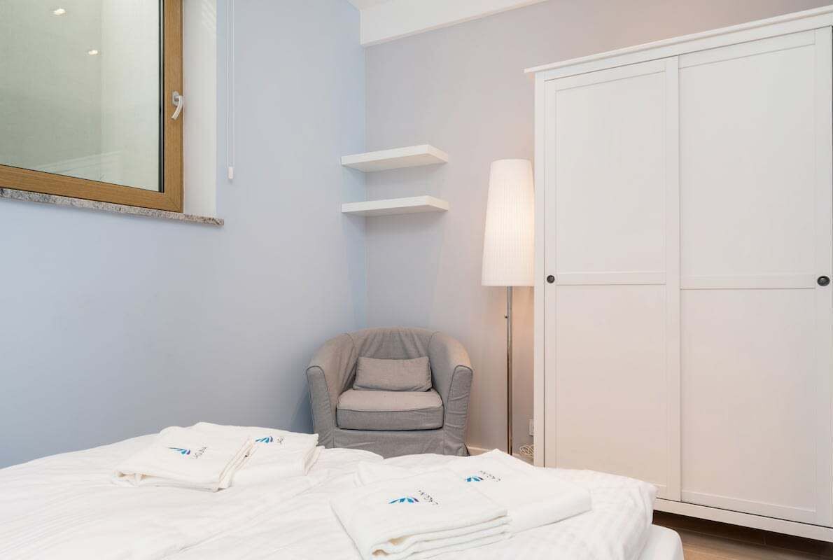 Ein Hotelzimmer mit Bett, Stuhl, Kleiderschrank und Spiegel.