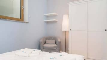 Ein Hotelzimmer mit Bett, Stuhl, Kleiderschrank und Spiegel.