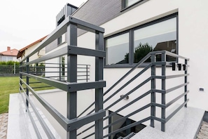 A modern building with a metal staircase and a glass window. - Apartment Close to Lake | Jacuzzi | Sauna (Kolczewo)