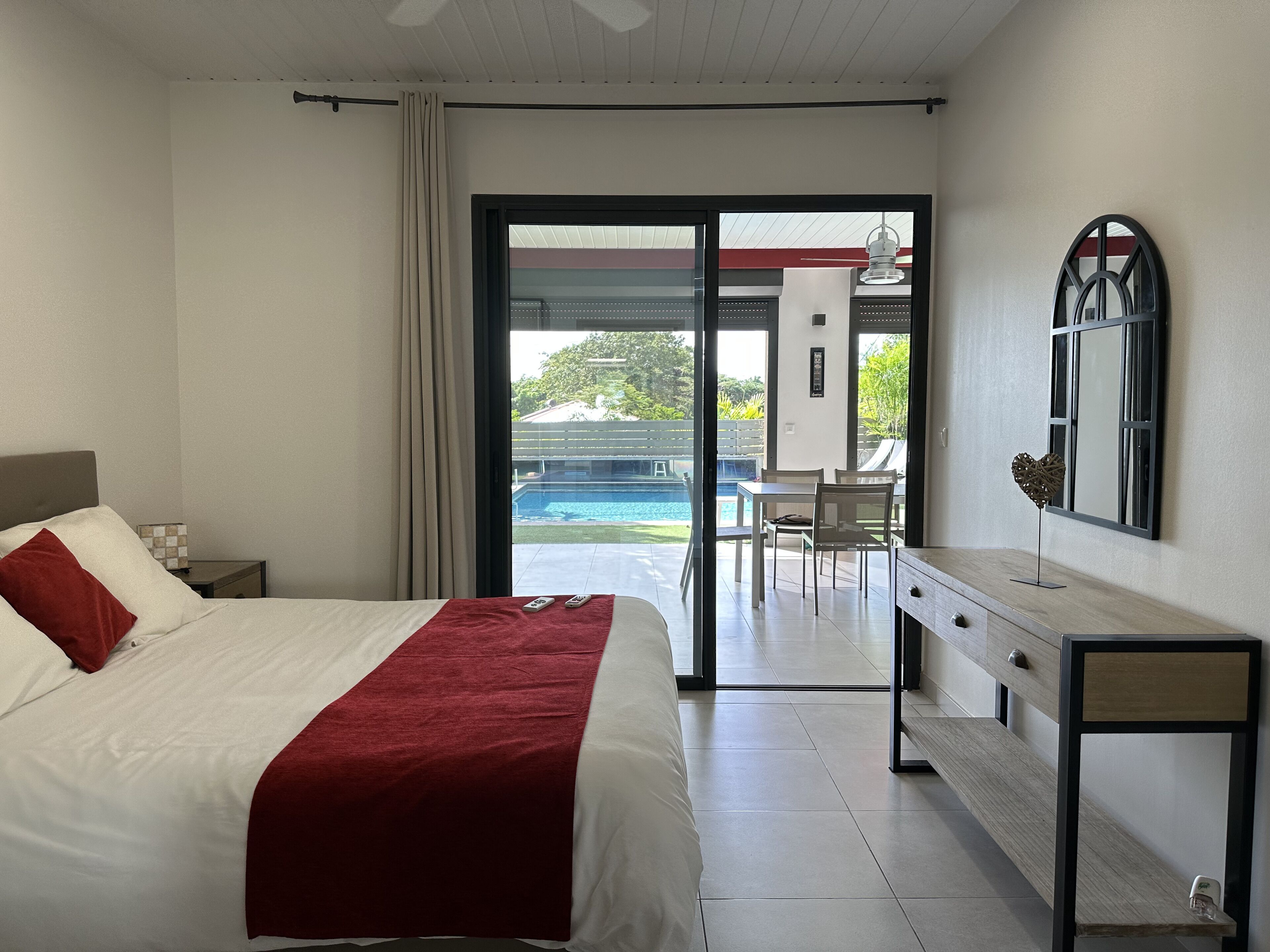 Ein Hotelzimmer mit Bett, Schreibtisch und Blick auf einen Außenpool.