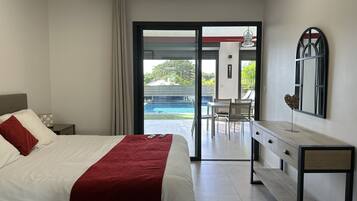 Ein Hotelzimmer mit Bett, Schreibtisch und Blick auf einen Außenpool.