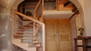 Un escalier en bois avec une rampe métallique menant à une mezzanine.