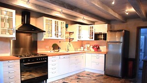 A kitchen with white cabinets, a stainless steel stove, and a refrigerator. - Charming Small Farmhouse 600 M FROM THE BEACHES  (Cancale)