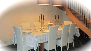 A dining room with a table set for six, featuring a chandelier, candelabras, and a staircase in the background. - Charming Small Farmhouse 600 M FROM THE BEACHES  (Cancale)