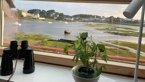 A view from a window with binoculars and a potted plant on a table. -  Fisherman's house with exceptional view of the back port, close to the beaches (Treffiagat)