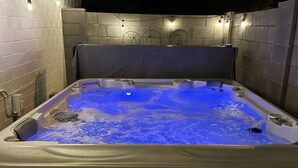 A hot tub with a blue light, surrounded by tiled walls and a wooden floor. - Old Town Scottsdale - With a pool, hot tub,  Putting Green, Billiards. (Scottsdale)