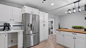 A modern kitchen with white cabinets, stainless steel appliances, and a wooden countertop. - Old Town Scottsdale - With a pool, hot tub,  Putting Green, Billiards. (Scottsdale)