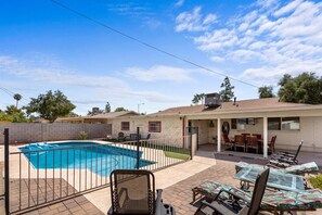 A backyard with a swimming pool, patio furniture, and a covered seating area. - Old Town Scottsdale - With a pool, hot tub, Putting Green, Billiards. (Scottsdale)