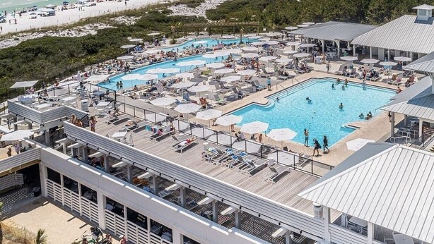 Un complexe hôtelier doté de plusieurs piscines, d’un accès à la plage et d’un espace abrité avec des chaises longues et des parasols.