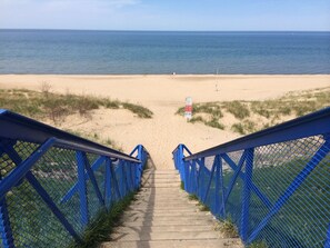 A staircase leading to a beach with a clear view of the ocean.