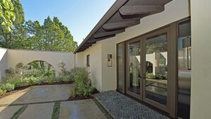 Ein modernes Gebäude mit einem Rochenmuster-Weg, großen Glasüren und einem angelegten Garten.