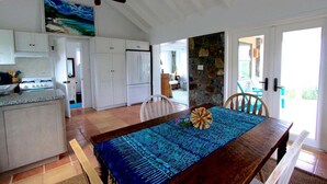 A spacious kitchen with white cabinets, a large island, and a ceiling fan. - Mesmerizing view with pool 2 bedroom stone cottage in Coral Bay (St John)