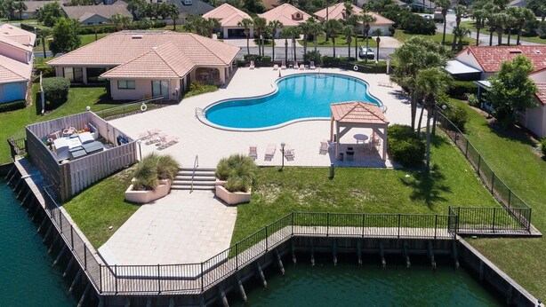 A residential area with a swimming pool, a dock, and a gazebo.