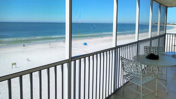 Un balcon avec vue sur une plage et l’océan.