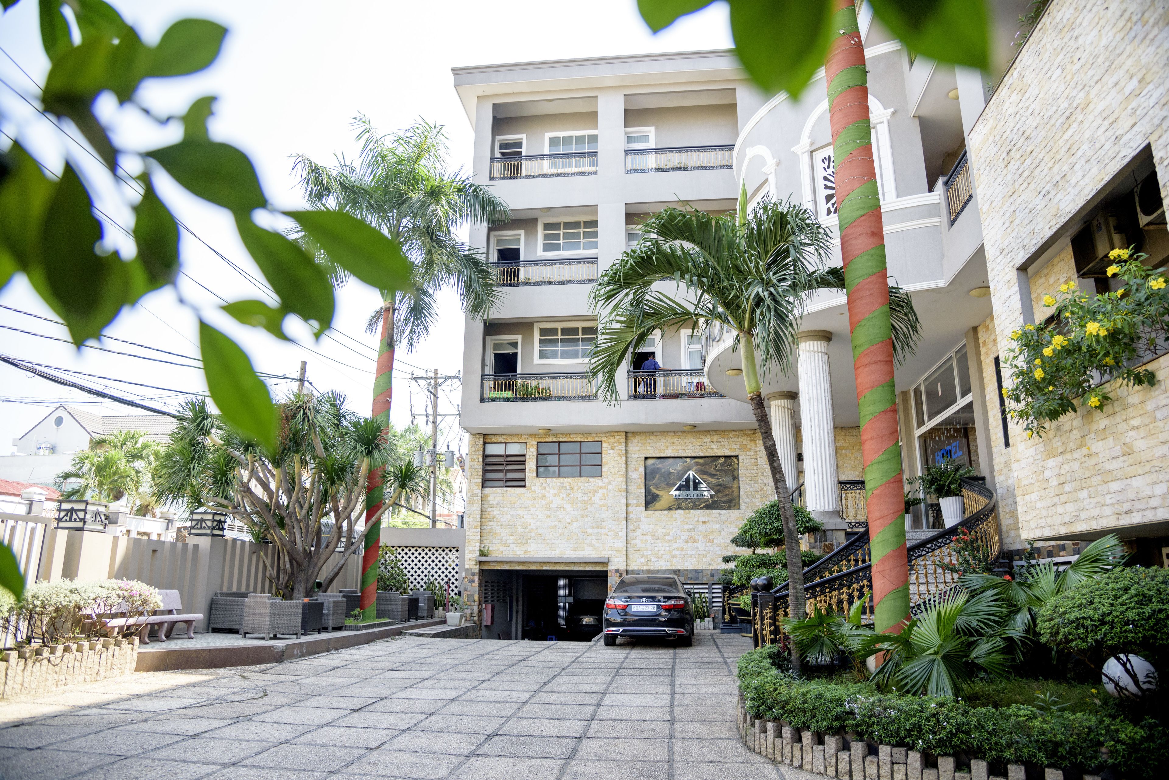 A multi-story building with a central entrance, balconies, and a staircase leading to the upper floors.