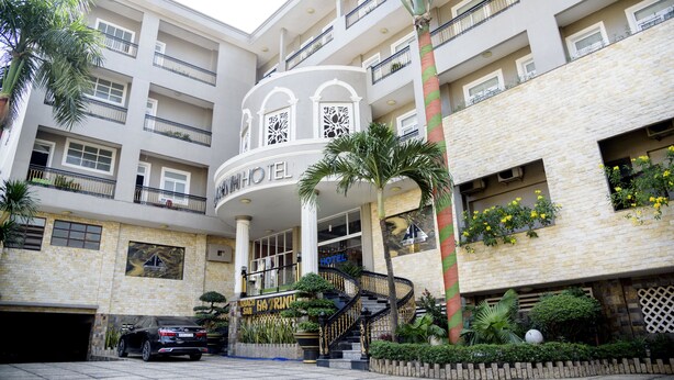 A multi-story hotel with a central atrium, balconies, and a staircase.