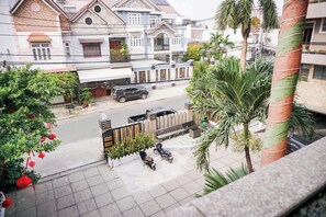 A residential street with houses, a parked car, and a scooter. - Ha Trinh Hotel (Bien Hoa)