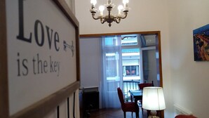 Una stanza con un lampadario, un tavolo da pranzo con sedie e un cartello con su scritto 'Love is the key'.