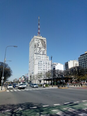 A tall building with a distinctive mural on its facade, surrounded by urban streets and other buildings. - Mundo Vita (Buenos Aires)