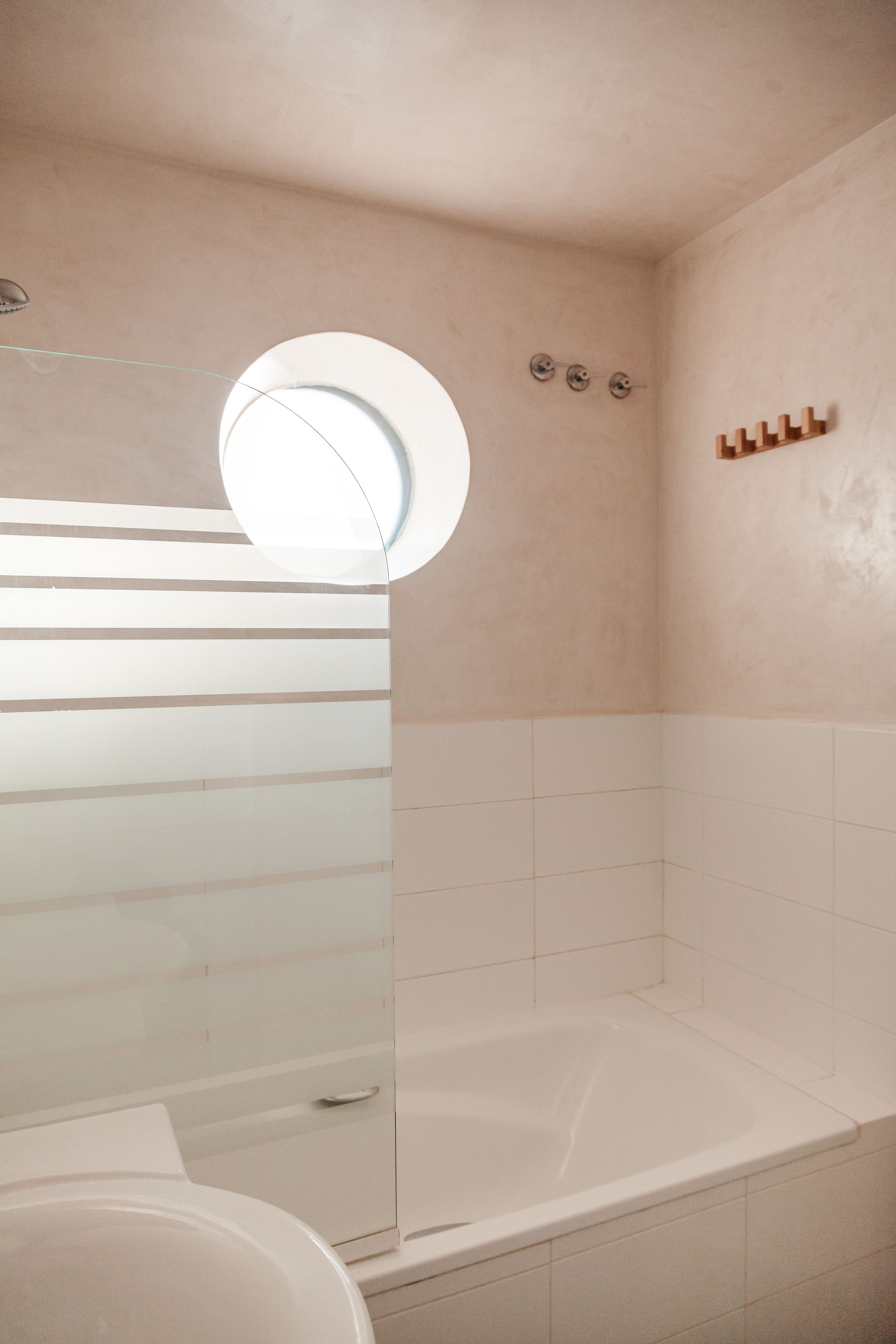 A modern bathroom with a glass shower enclosure, a bathtub, and a toilet.