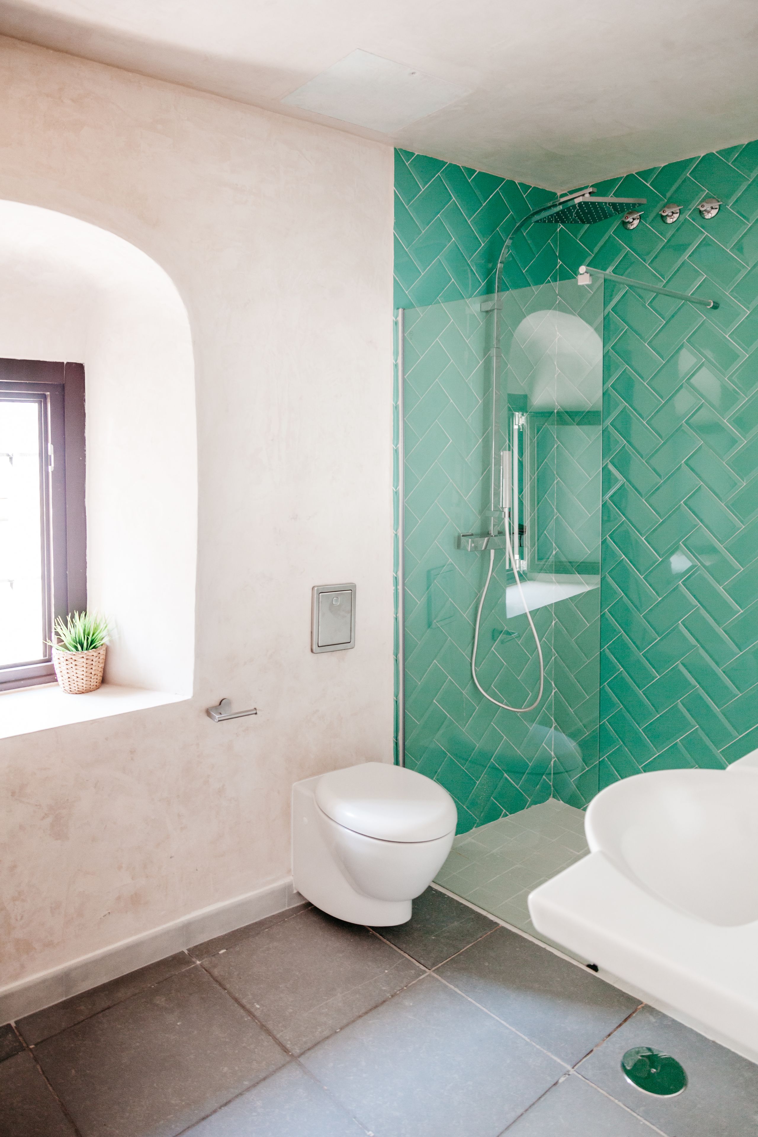 A bathroom with a toilet, a glass-enclosed shower, and a bathtub.