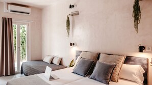 A bedroom with a large bed, a smaller bed, a laptop on the larger bed, and a window with curtains. - Astuto Boutique Jerez - Adults Only (Jerez de la Frontera)