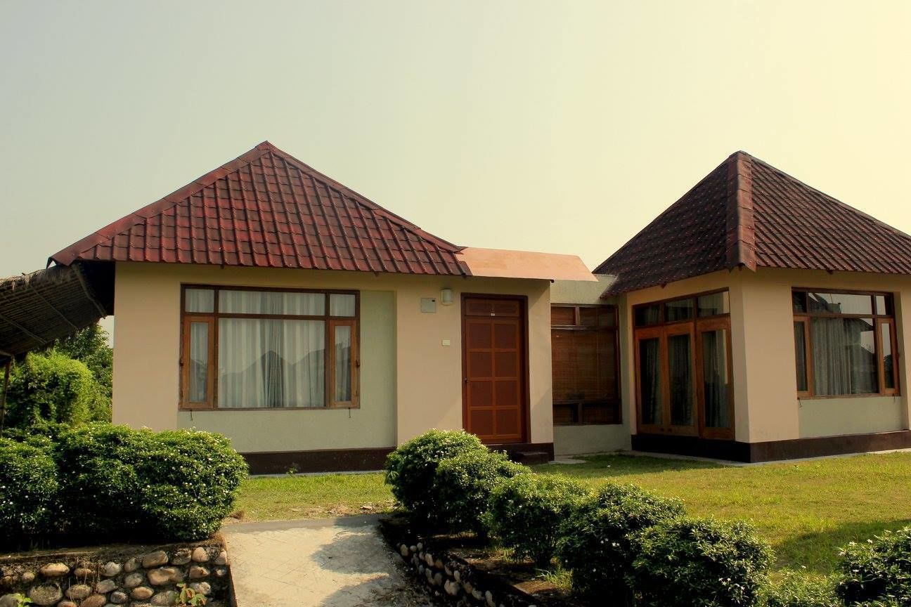 A two-story house with a red-tiled roof, large windows, and a stone pathway leading to the entrance.