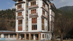 Un edificio de varios pisos con estilo arquitectónico tradicional, que presenta balcones de madera y un techo plano.