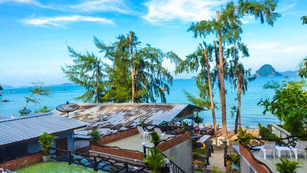 A coastal property with a patio area, outdoor seating, and a view of the sea.