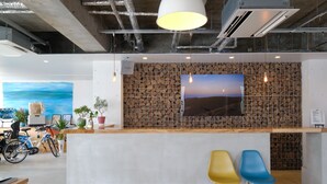 Una zona de recepción moderna con una pared de madera, un cuadro grande y dos sillas coloridas.